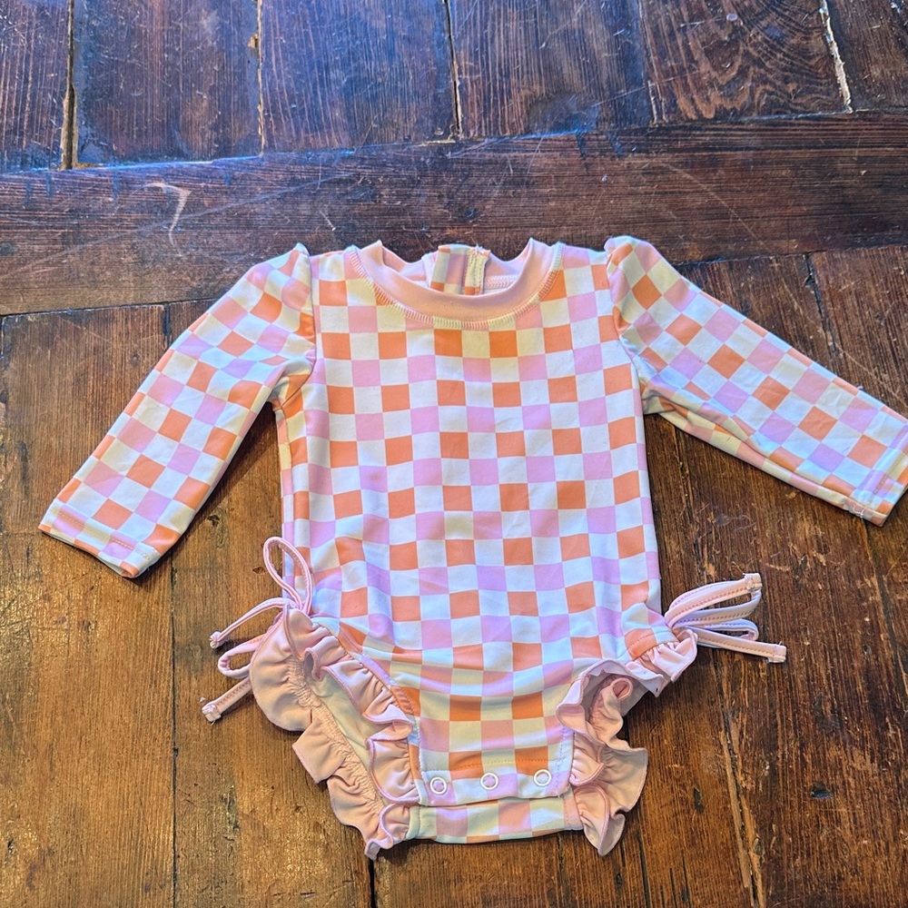 Caden Lane Checkerboard Pink & Peach Ruffle Long-Sleeve Baby Swimsuit.